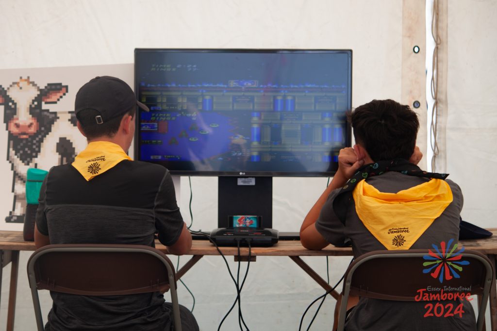 Two participants playing video games on a big screen.