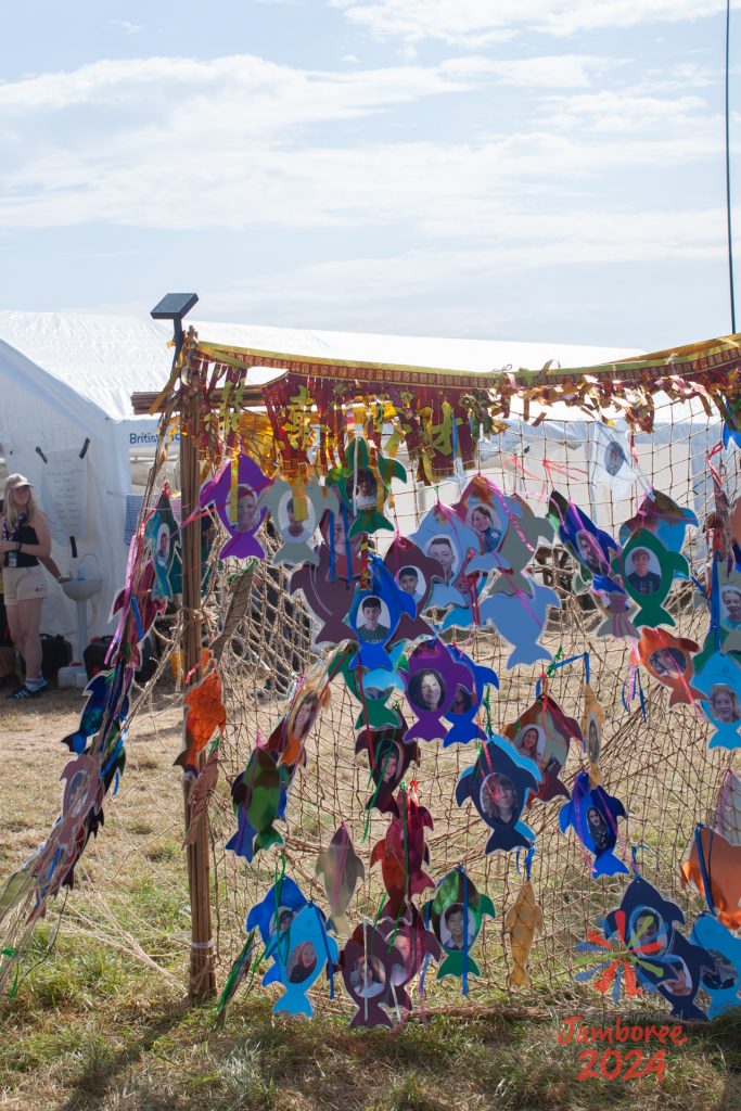 Some coloured cardboard fish with faces of participants on them