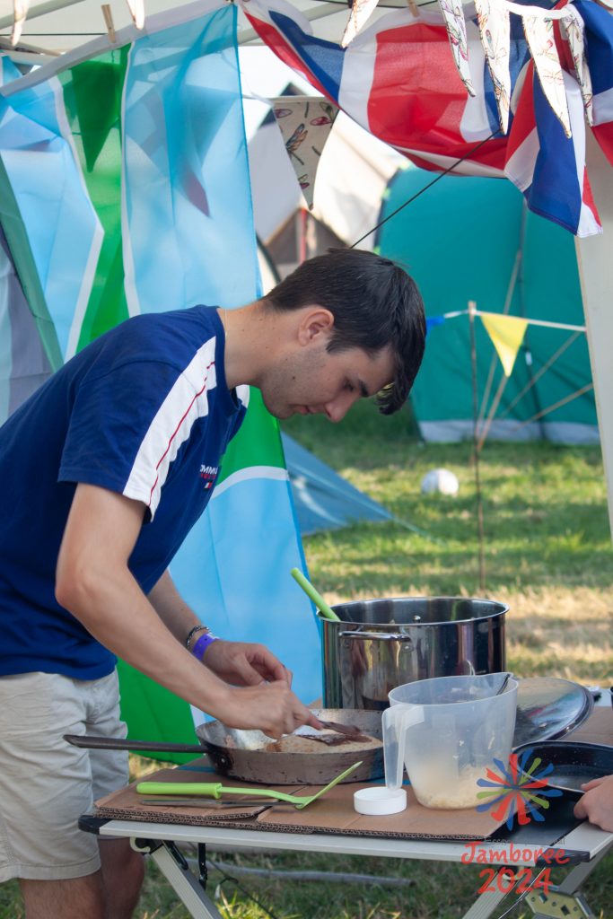 A person leaning over a frying pan, preparing some food. 