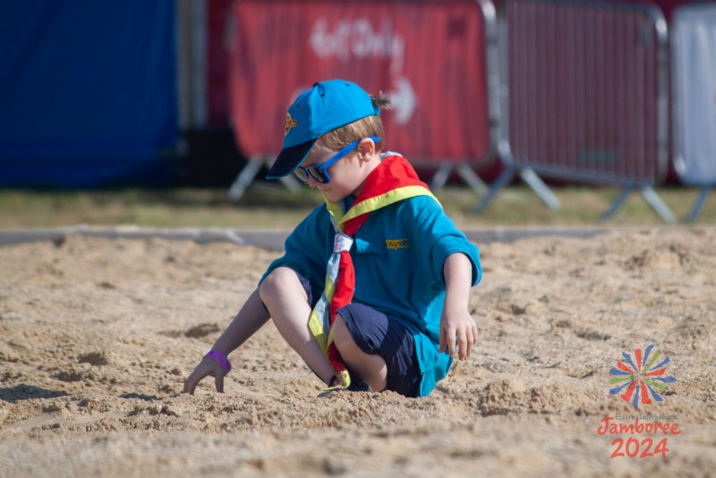 A Beaver Scout playing in the sand on the EIJ Beach.