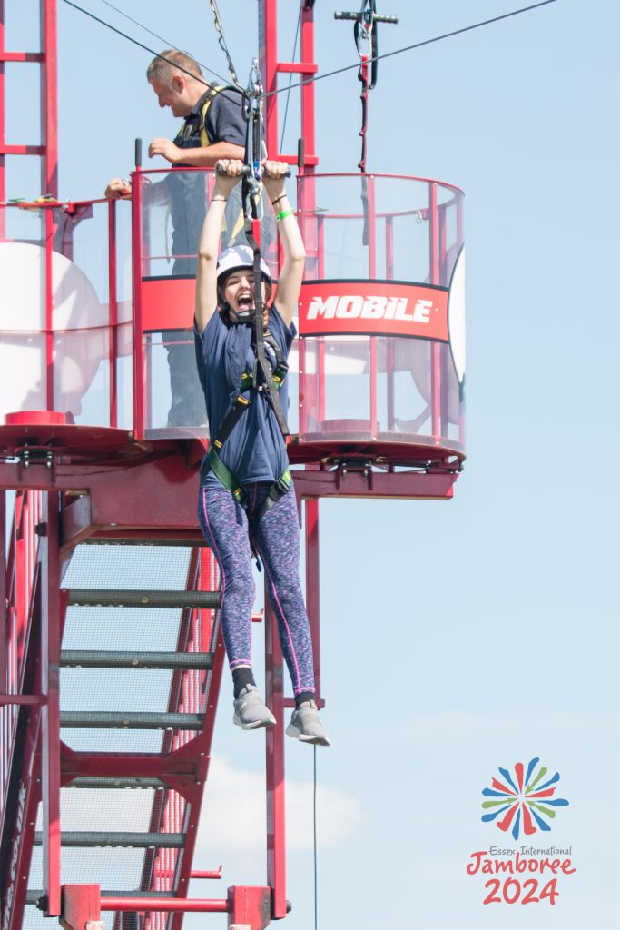 A young person on a zipline, screaming.