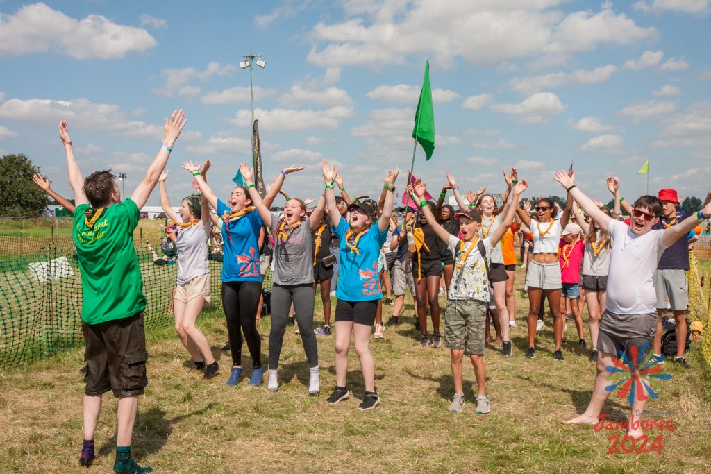 A group of young people with their hands in the air, dancing to the YMCA.