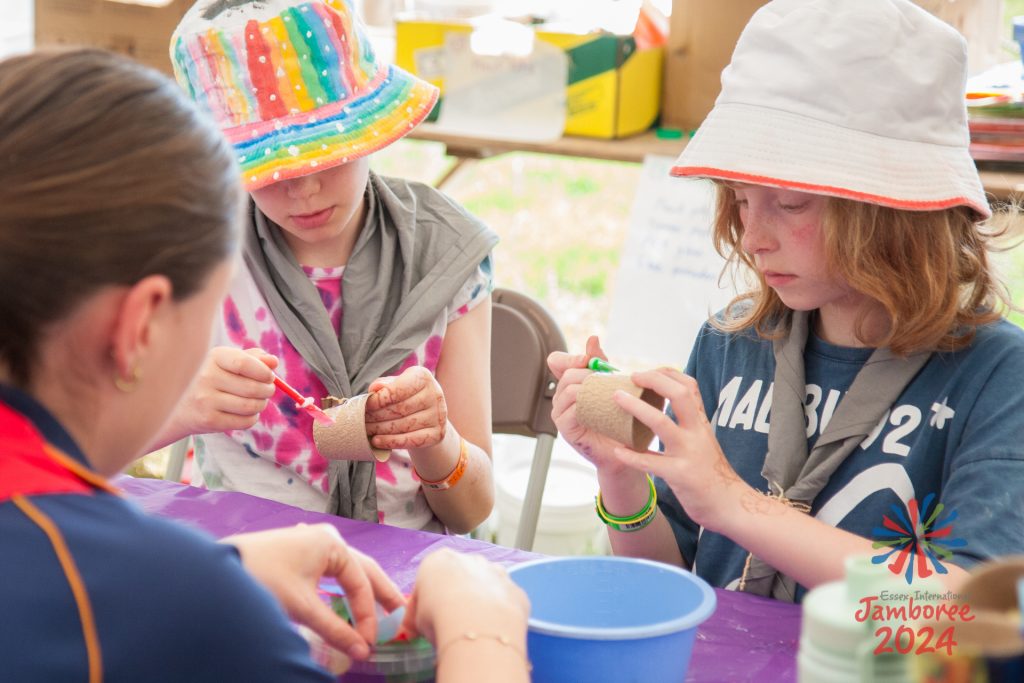 Three participants surrounding a table, taking part in crafts.