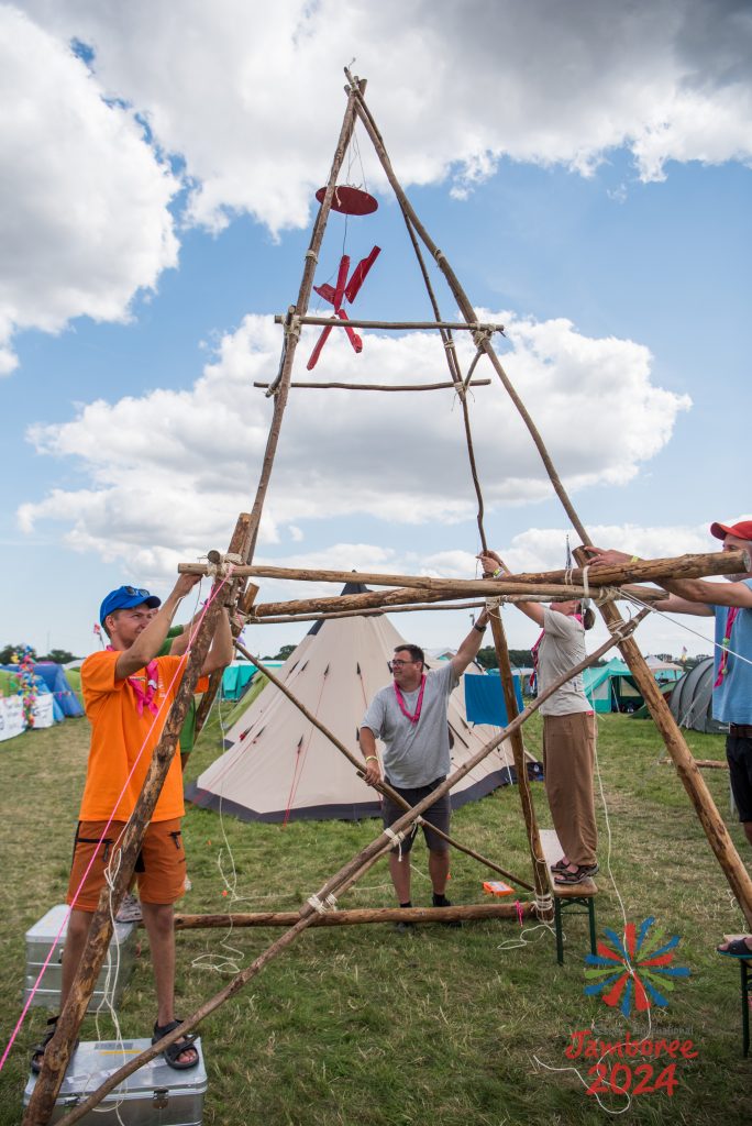 A tall tower built out of pioneering poles