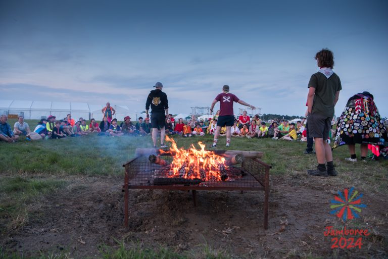 Participants huddled around a campfire.