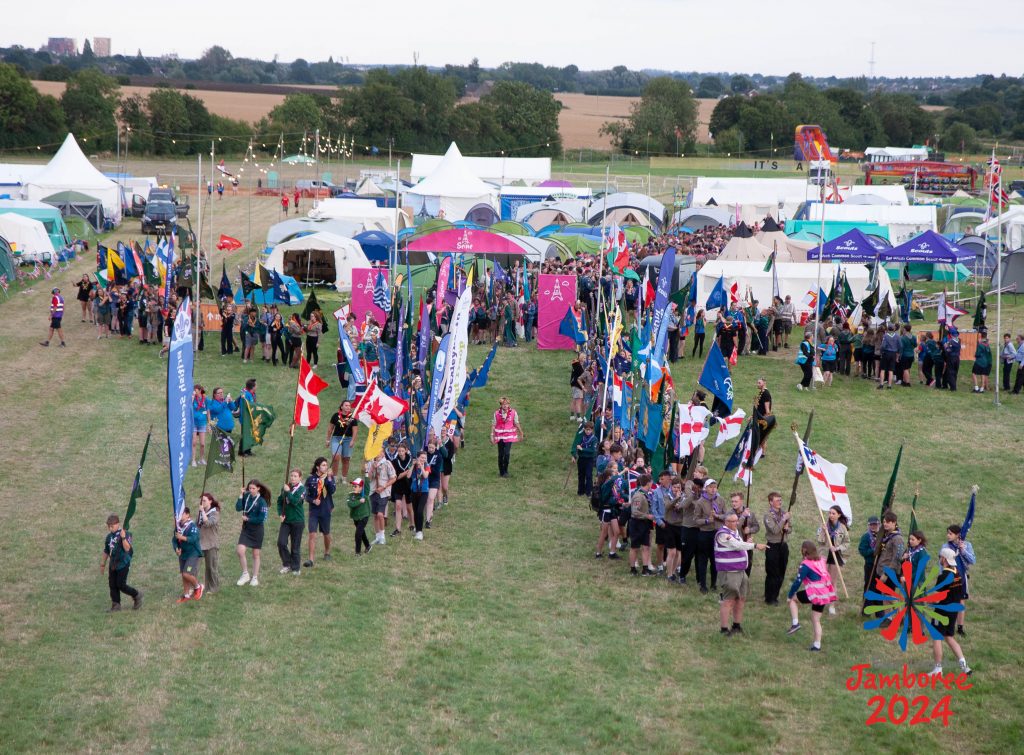 Young people holding flags, parading into the Main Arena. 