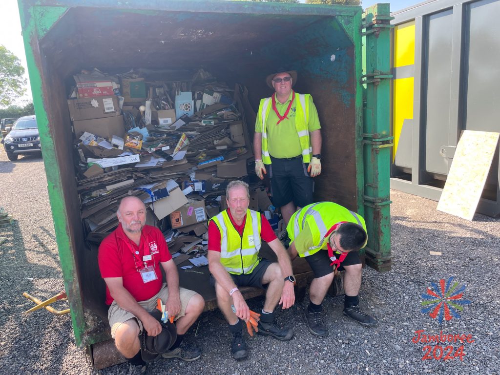 Some Staff members sit at the entrance to a large container full of cardboard ready fro recycling