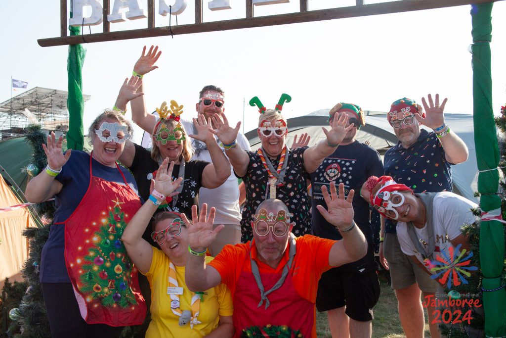 Leaders dress in Christmas costumes wave at the camera