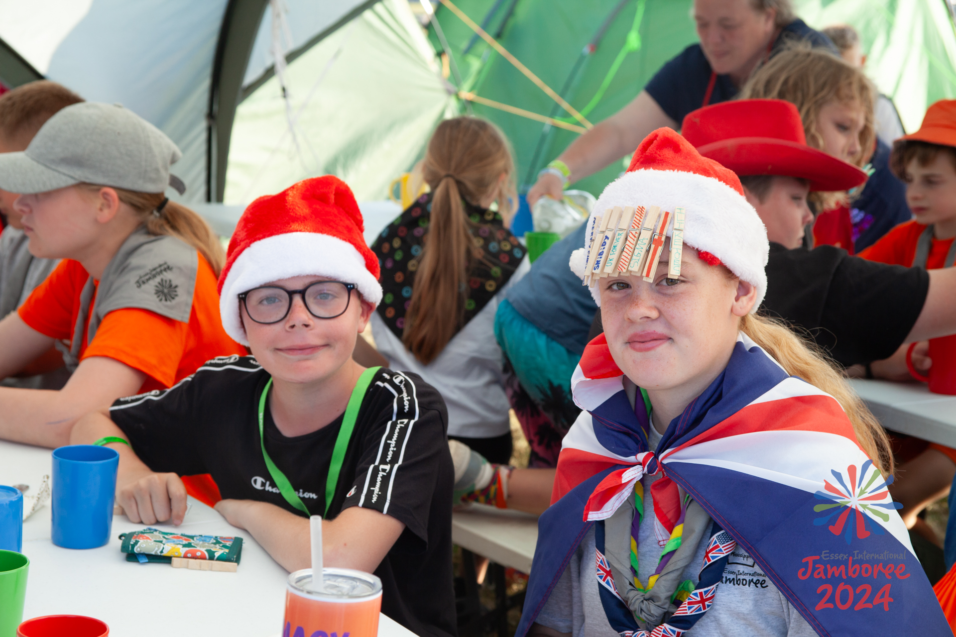 Participants sit at a dining table, wearing Christmas hats