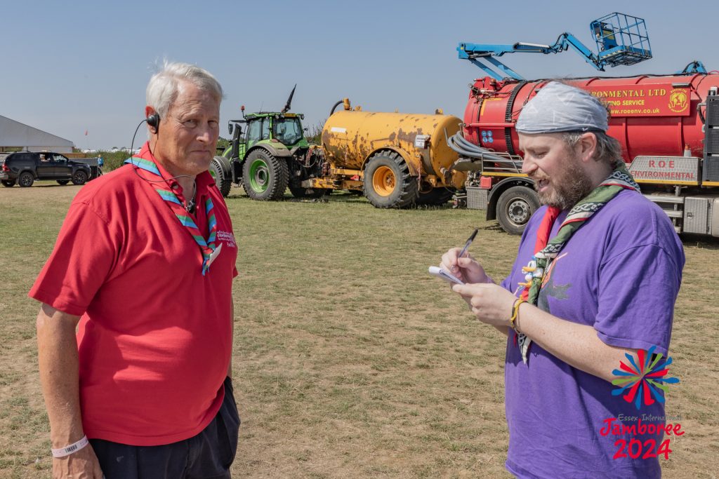 A reporter takes notes while a member of the Facilities Team answers the questions