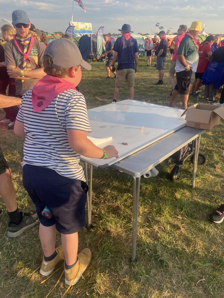 A young person rolling pennies along a board.