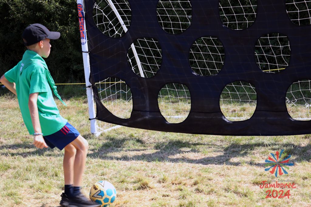 A Participants lines up a kick of a ball into one of a selection of targets hanging from a football goal