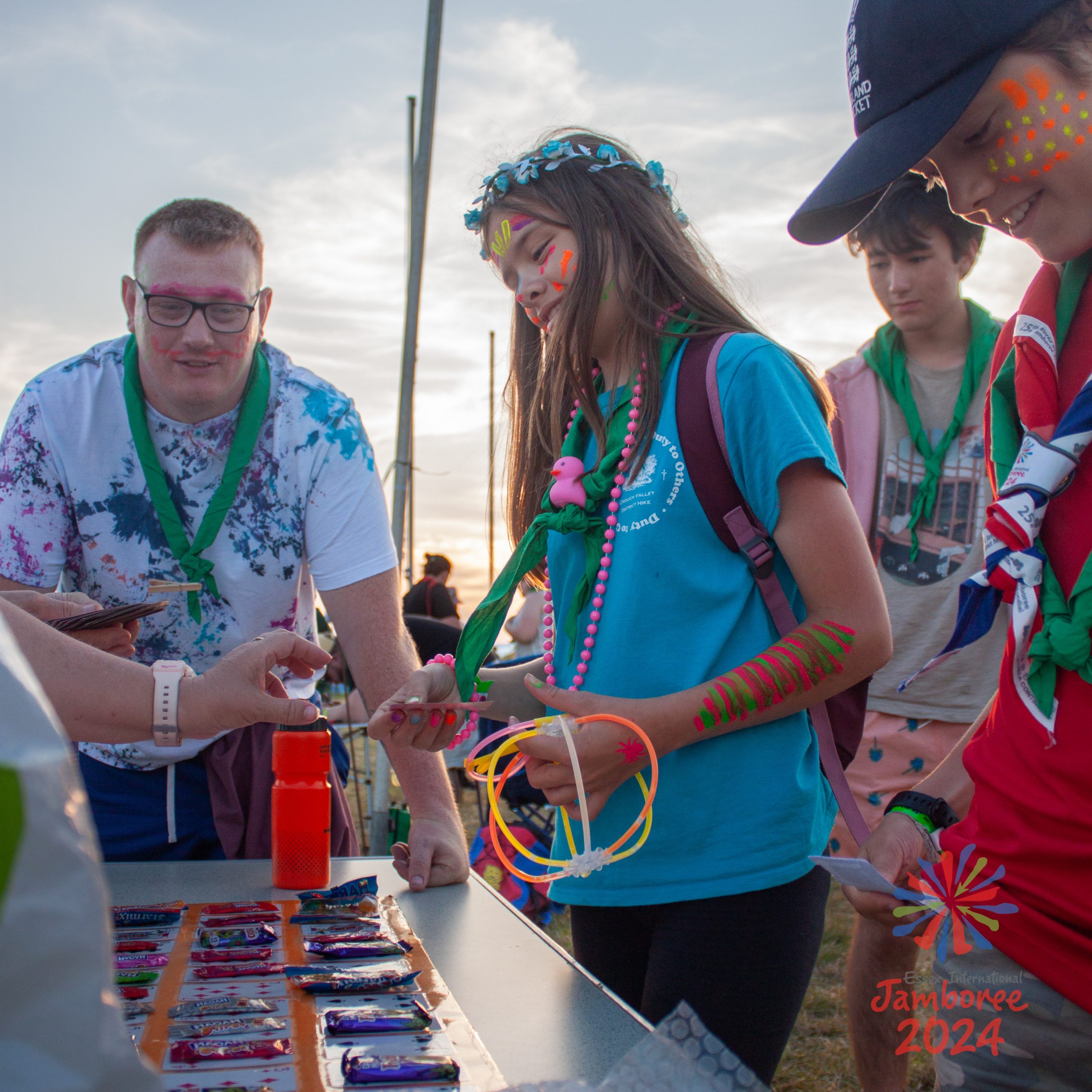 Young people having fun playing a card game, while wearing neon paint.