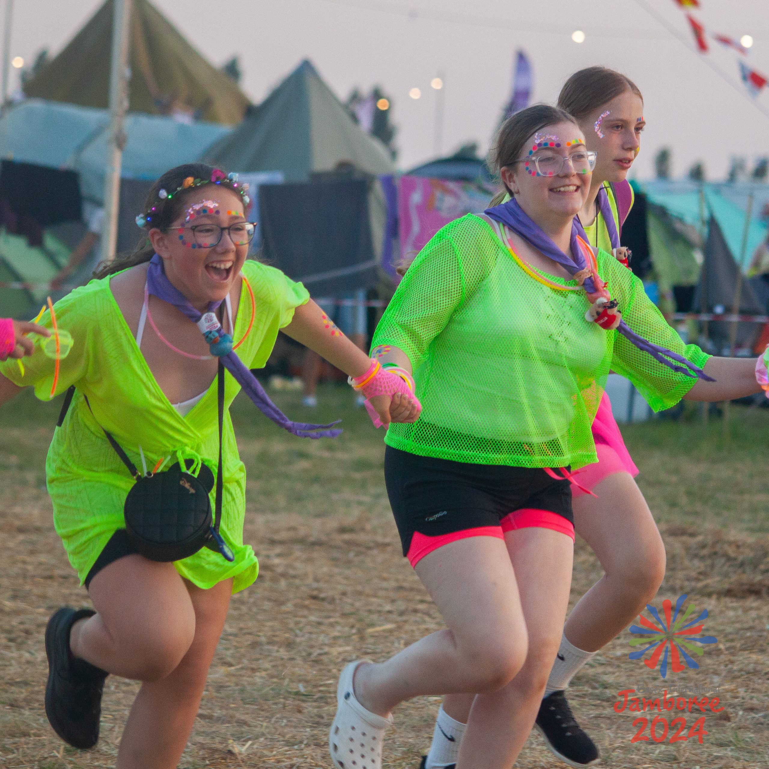 Young people running in neon clothing.