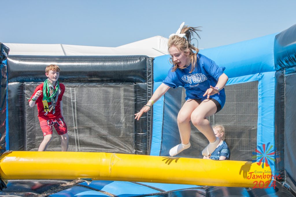 A Participant clears a spinning bar in and inflatable jumping zone