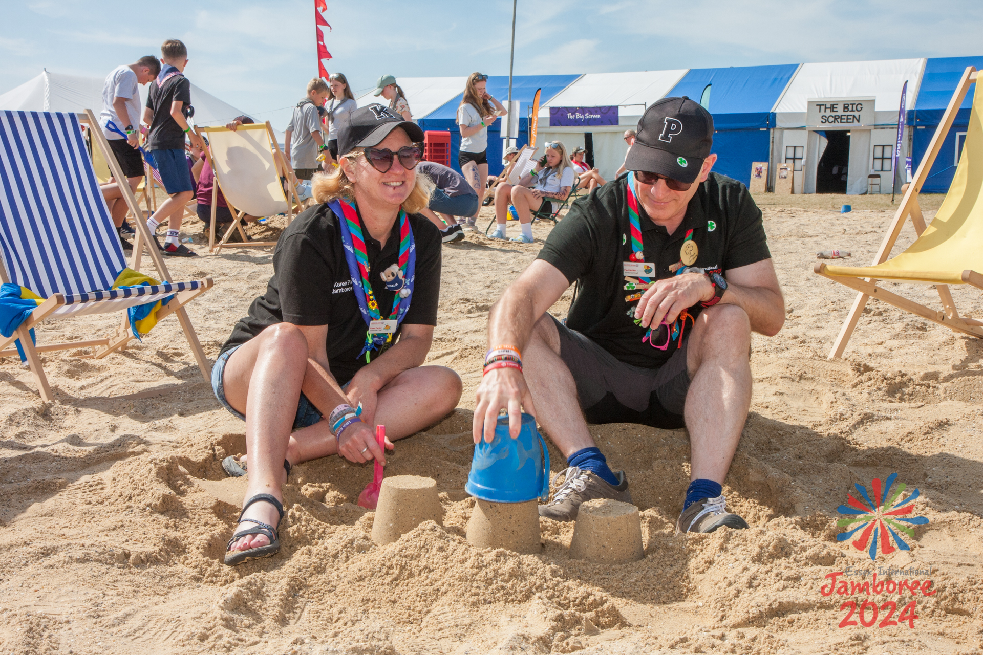 Karen and Paul sitting on the EIJ 2024 beach, building sandcastles.