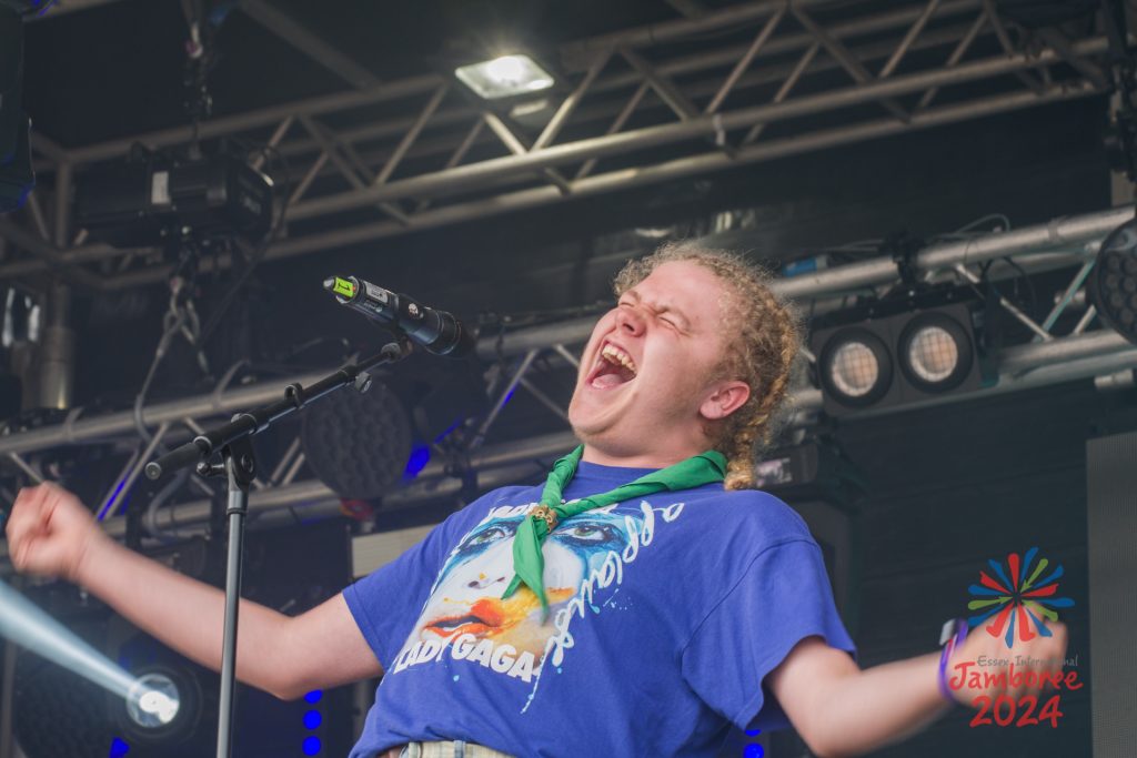 A participant leaning backwards as they sing into a microphone.