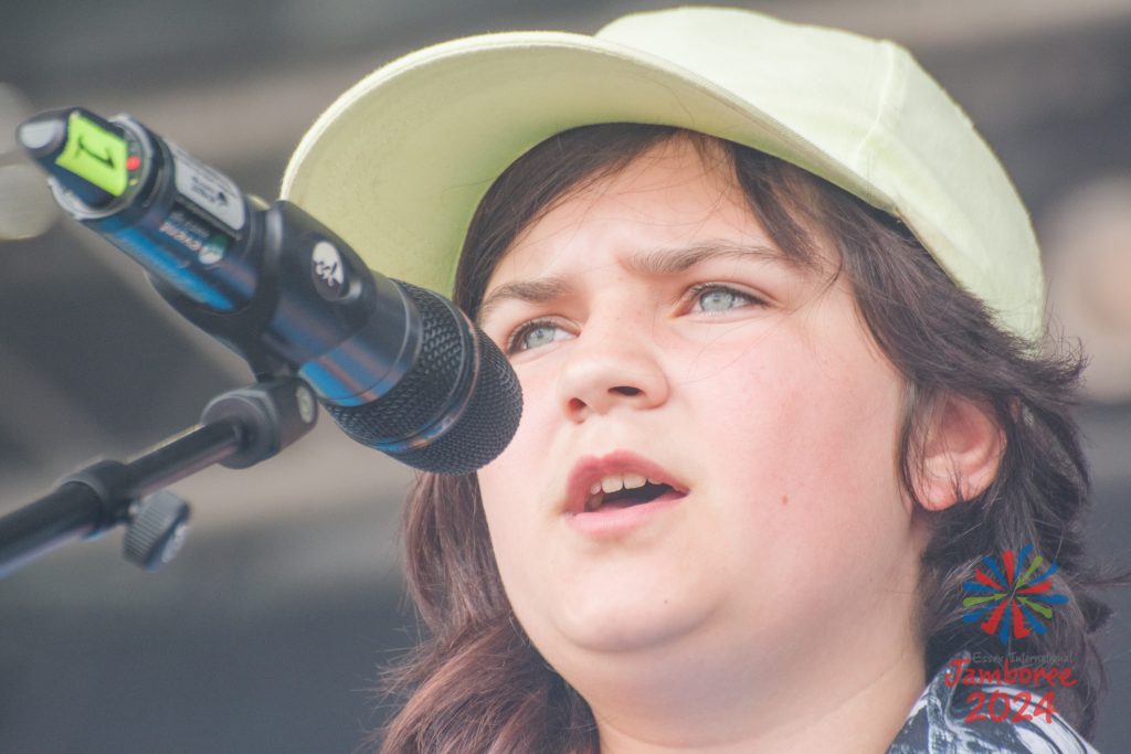 A close-up of a participant singing into a standing microphone. 