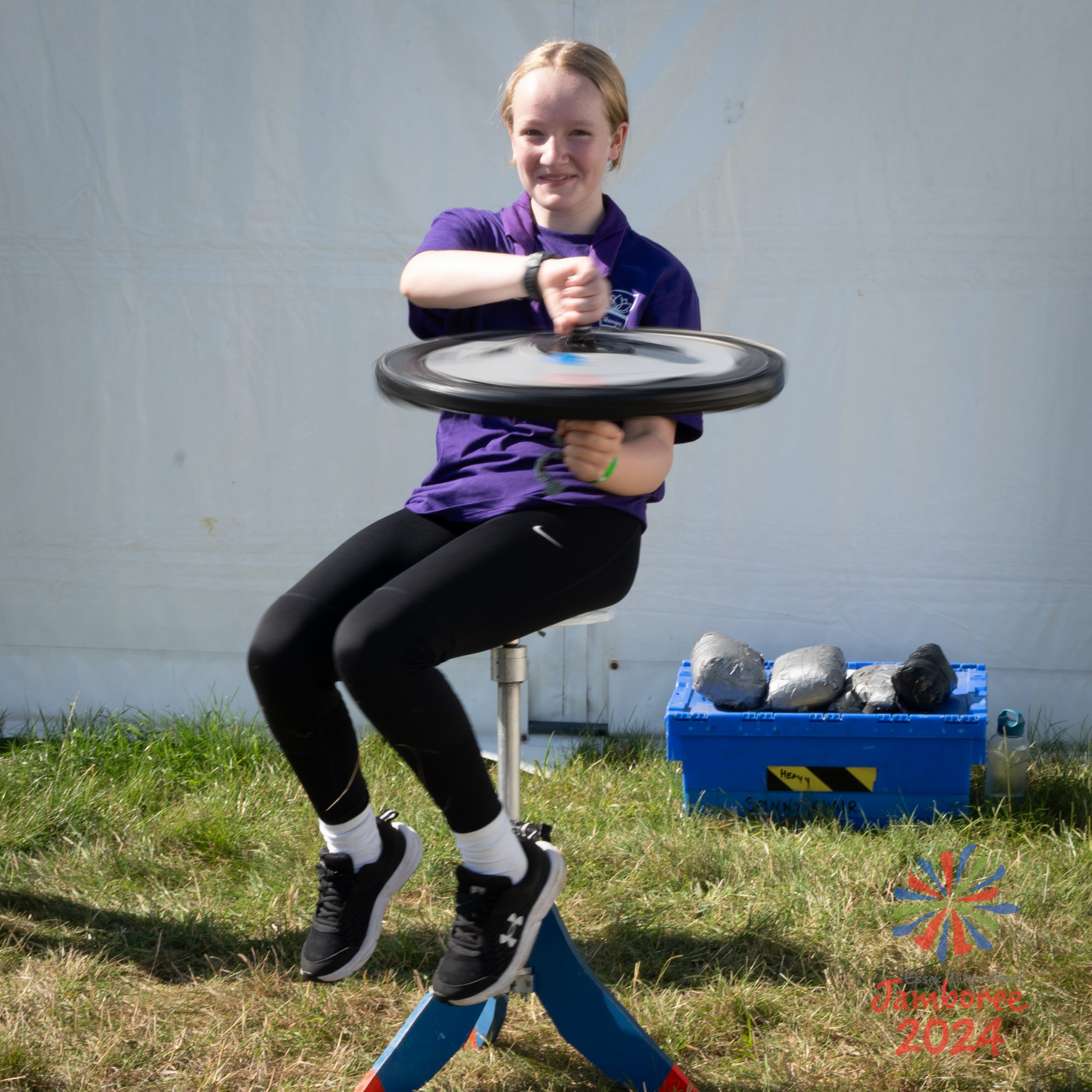 A young person holding a bicycle wheel, in a demonstration of gyroscopic precession.