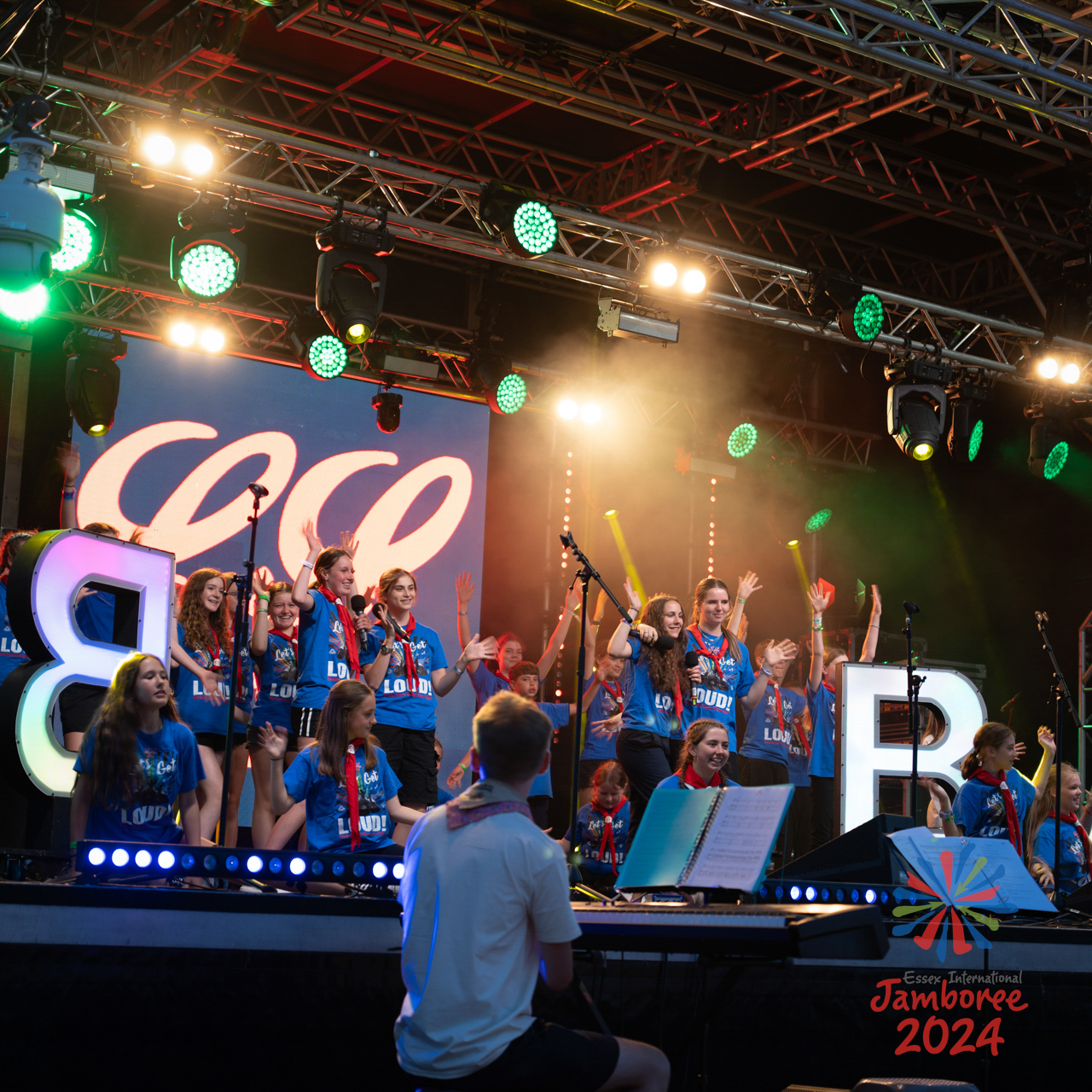 Young people singing and dancing on stage as part of Gang Show evening. 