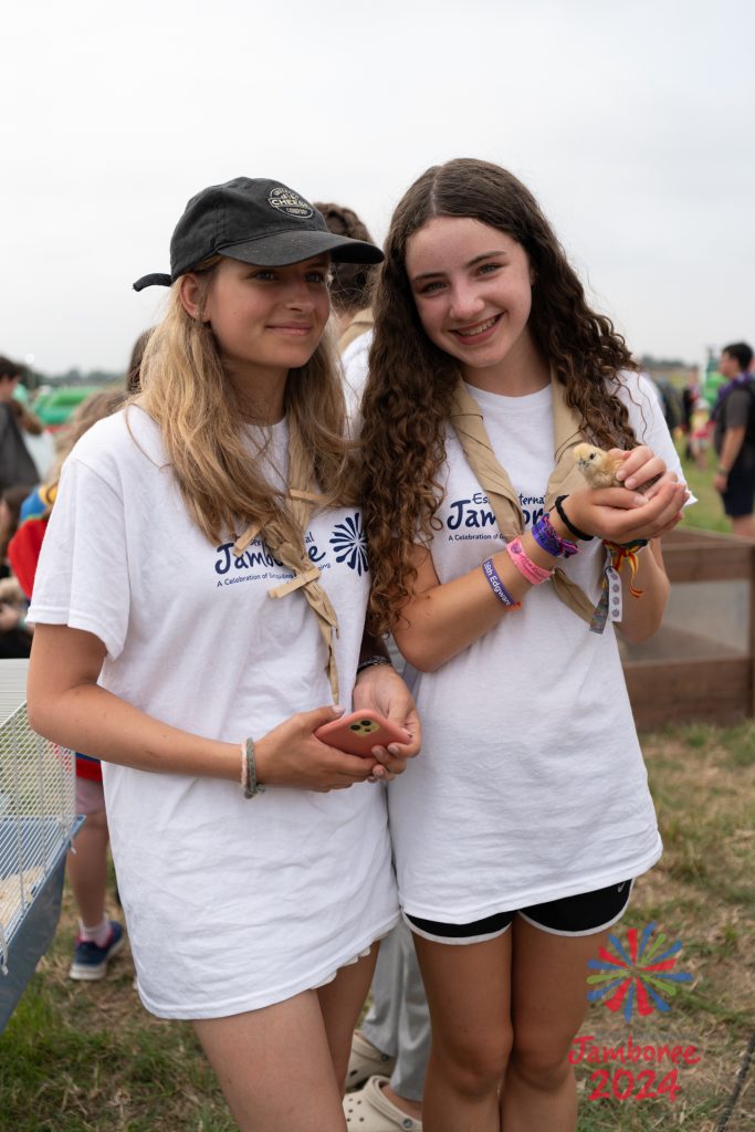 Two girls from Nile subcamp posing for the camera. The one on the right is holding a duckling. 