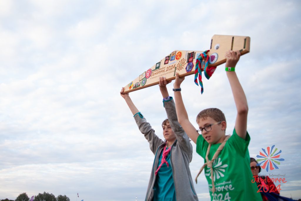 Two participants hold Peggy ( a giant tent peg) aloft