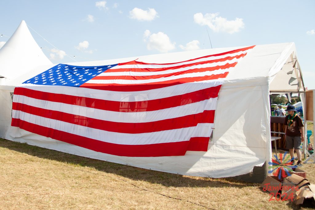 A large U.S. Flag draped over the roof and side of a tent