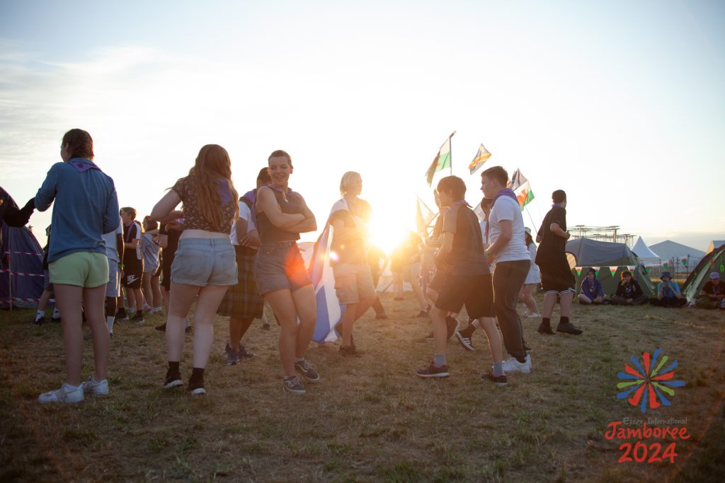 Participants dancing, with the sun shining between them.