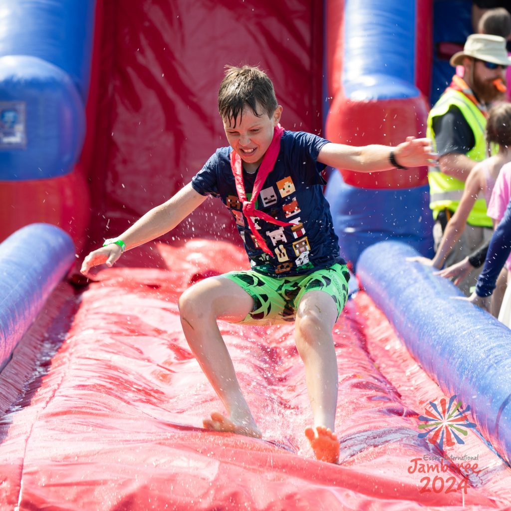 A young person sliding down an inflatable water slide.