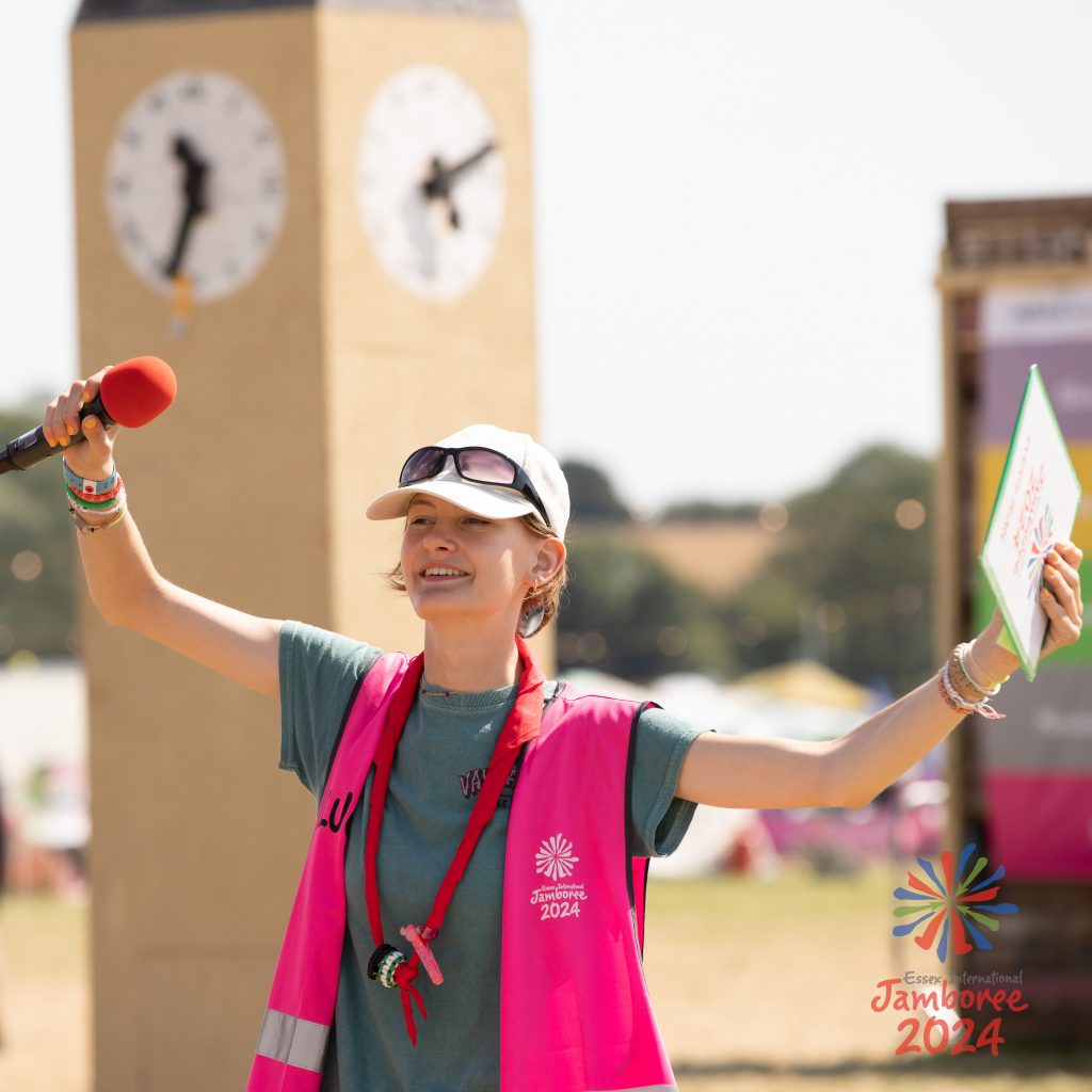 A volunteer waving their arms in the air, marshalling.