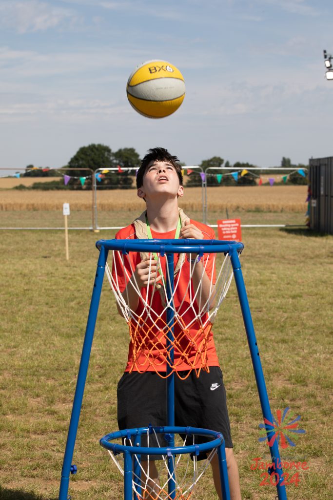 A young person throwing a basketball into a hoop.