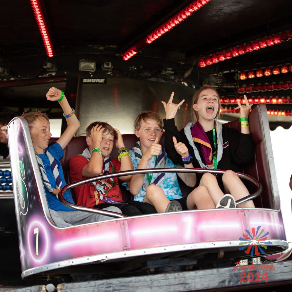 Young people on a fairground ride, posing.